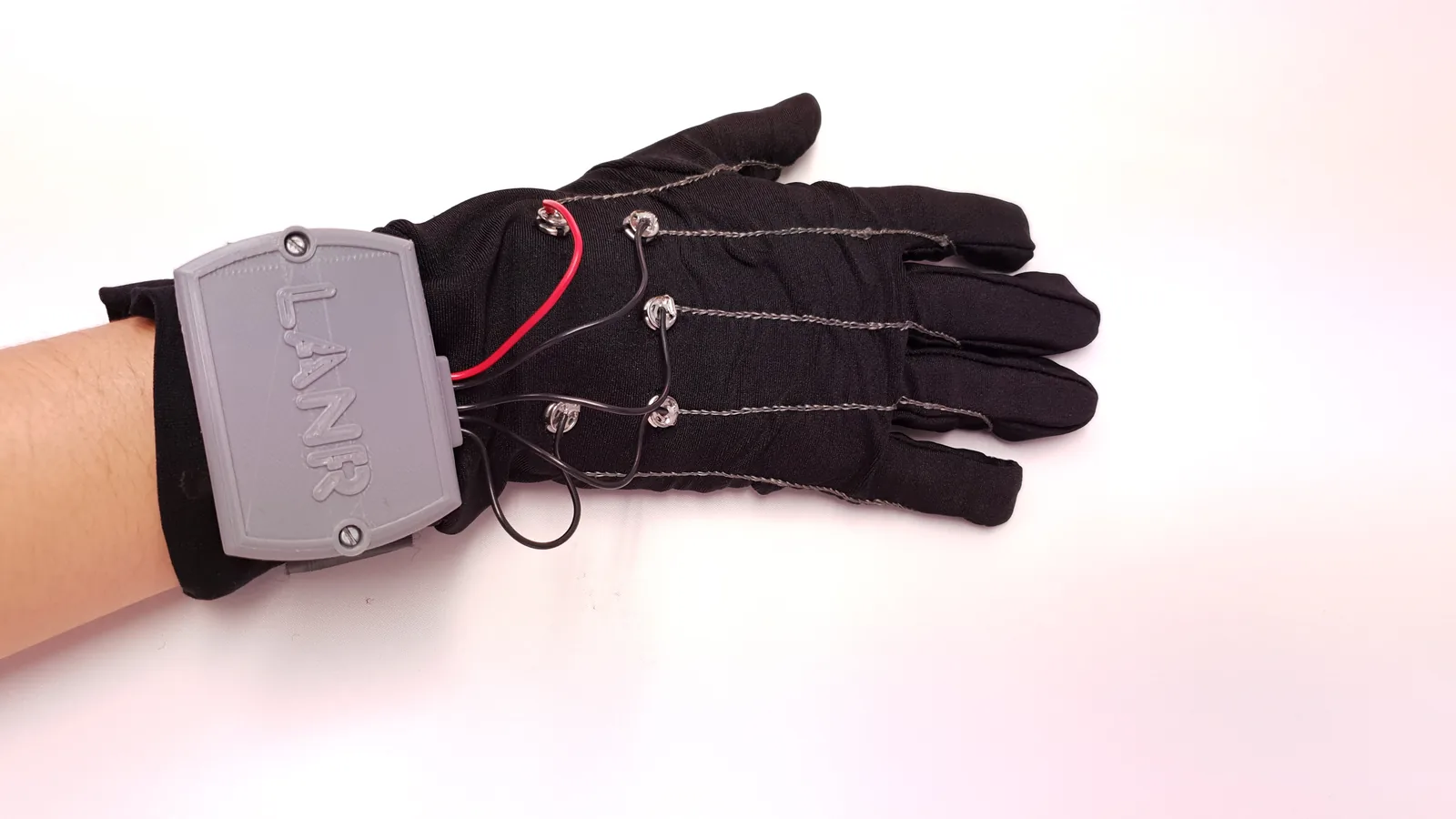 Black sensor glove with stitched conductive lines and a grey LANR-branded wrist module, on a white background.
